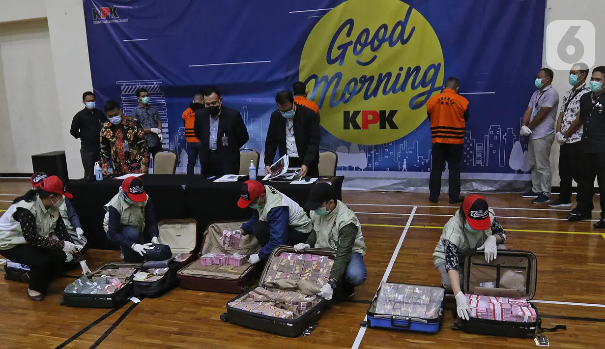 Penyidik KPK menunjukan barang bukti uang tunai saat konferensi pers terkait Operasi Tangkap Tangan (OTT) atas kasus dugaan suap bansos penanganan covid-19 Kementerian Sosial, di Jakarta, Minggu (6/12/2020). Kasus ini menjerat Mensos Juliari Batubara jadi tersangka. (Liputan6.com/Herman Zakharia)