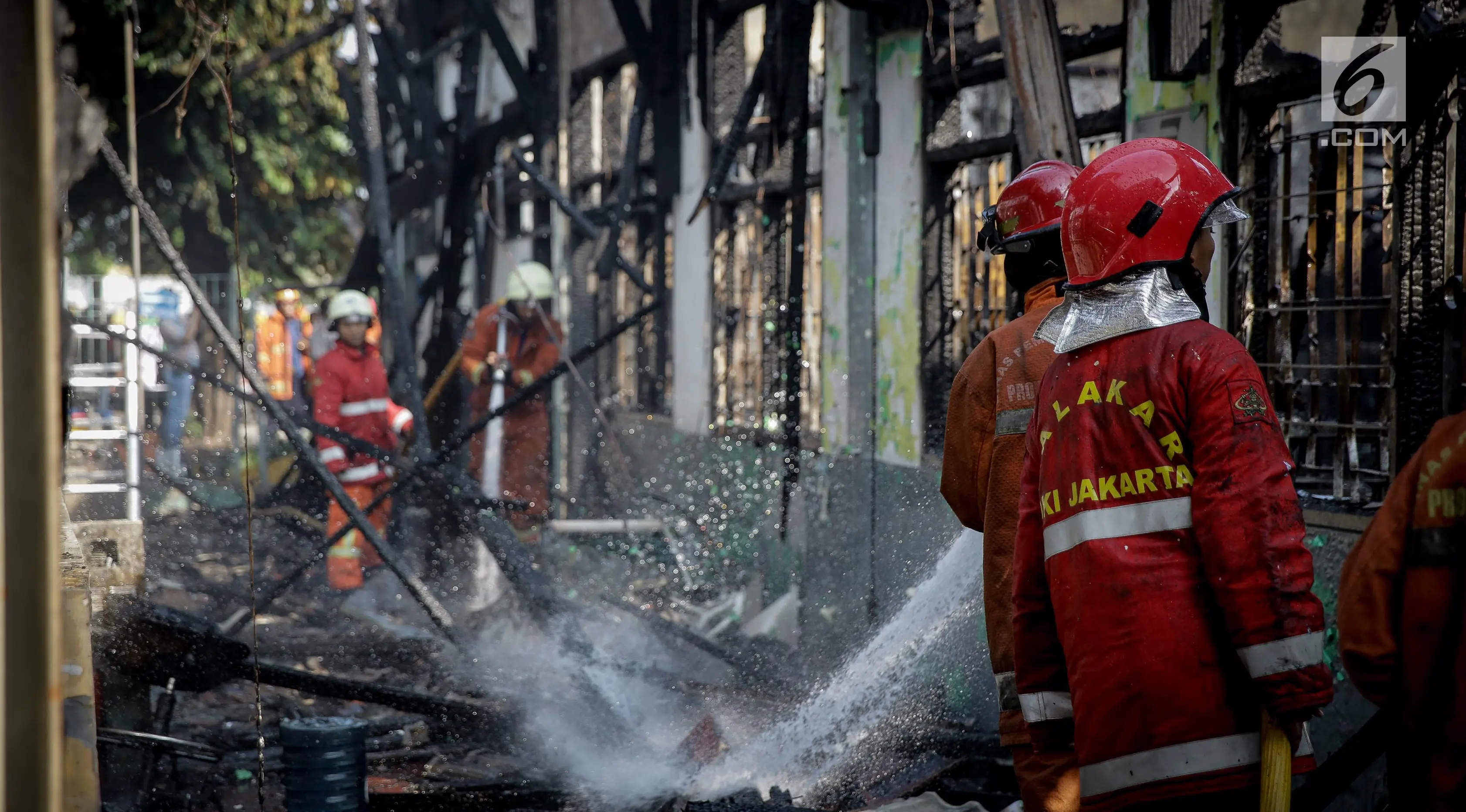 Petugas melakukan pendinginan pada Stasiun Klender, Jakarta Timur, yang terbakar, Jumat (19/5). Akibat kebakaran, operasional naik-turun penumpang kereta api listrik (KRL) di stasiun itu dihentikan untuk sementara waktu. (Liputan6.com/Faizal Fanani)