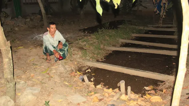 Resmihar ketika menunjukkan limbah kotoran sapi yang sudah terpisah dari tampungan biogas di belakang rumahnya. (Liputan6.com/Ahmad Adirin)