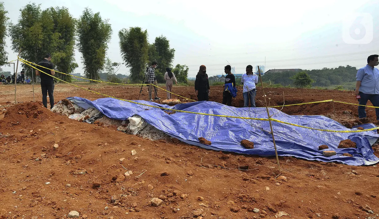 Warga memeriiksa tempat penemuan beras diduga bansos presiden di kawasan Kampung Serab, Sukmajaya, Depok, Jawa Barat, Rabu (3/8/022). Dari pemeriksaan sementara diketahui pihak JNE mengubur beras bansos Covid-19 itu pada 5 November 2021. (merdeka.com/Arie Basuki)