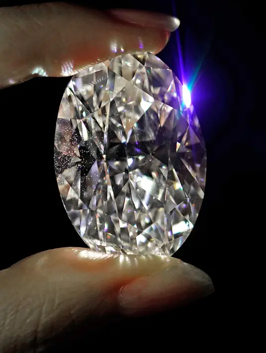 Sebuah berlian putih 102,39 karat, yang dikenal sebagai warna D, tanpa cela dipamerkan oleh model di ruang lelang Sotheby di Hong Kong, Senin (28/9/2020). Ini adalah pertama kalinya dalam sejarah, berlian dengan ukuran dan kaliber tersebut akan dilelang tanpa harga reservasi. (AP Photo/Vincent Yu)