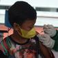 Seorang anak mendapatkan vaksin covid-19  di Stadion Utama Gelora Bung Karno (GBK), Senayan, Jakarta, Sabtu (3/7/2021). Pemprov DKI menggelar vaksinasi massal bagi anak usia 12-17 tahun di Stadion GBK selama dua hari, yakni pada 3-4 Juli 2021. (merdeka.com/Imam Buhori)