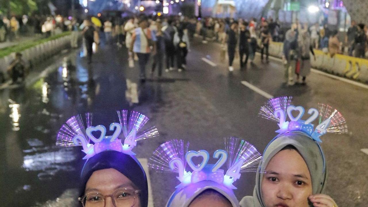 Warga berfoto selfie saat menikmati suasana "Malam Muda Mudi" di Bundaran HI.