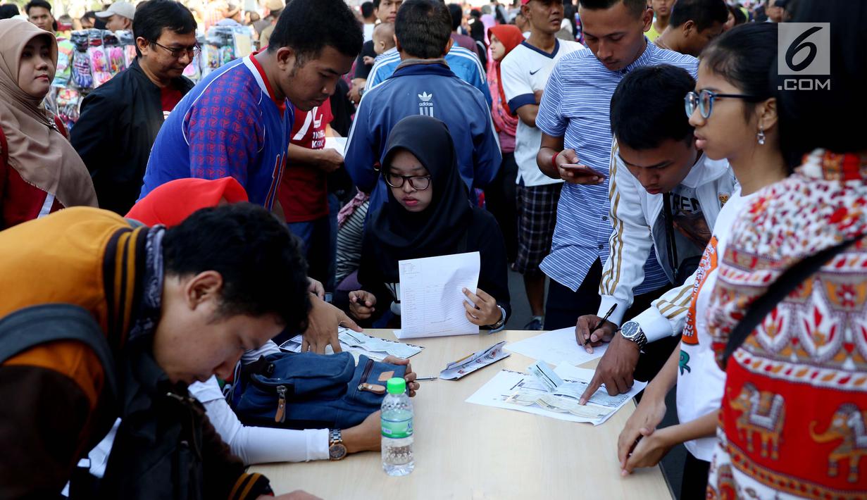 Sejumlah warga mengisi formulir untuk membayar pajak kendaraan bermotor di samsat keliling di car free day, Jakarta, Minggu (27/8). Caranya cukup menggunakan STNK dan membayar pajak sesuai yang tertera. (Liputan6.com/Angga Yuniar)