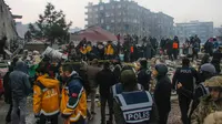 Orang-orang dan tim darurat menyelamatkan seseorang dengan tandu dari bangunan yang runtuh di Adana, Turki, Senin, 6 Februari 2023. Gempa berkekuatan magnitudo 7,8 telah menyebabkan kerusakan signifikan di tenggara Turki dan Suriah. (IHA agency via AP)