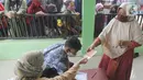 Warga menerima uang Bantuan Sosial Tunai (BST) bulan Januari di halaman Masjid Jami Al-Hidayah RW 01 Bedahan, Depok, Selasa (16/2/2021). Sekitar 159.470 Keluarga Penerima Manfaat (KPM) di Kota Depok menerima BST yang disalurkan PT Pos Indonesia pada Februari ini. (merdeka.com/Arie Basuki)