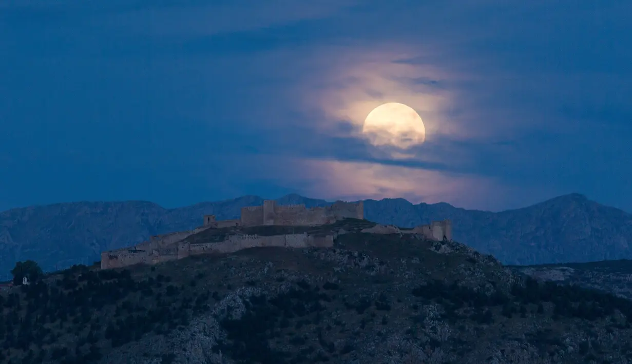 Bulan purnama terlihat di atas Kastil Larisa, Argos, Yunani, Kamis (7/5/2020). Fenomena supermoon atau di belahan Bumi lain disebut flower moon ini merupakan yang terakhir di tahun 2020. (Xinhua/Marios Lolos)