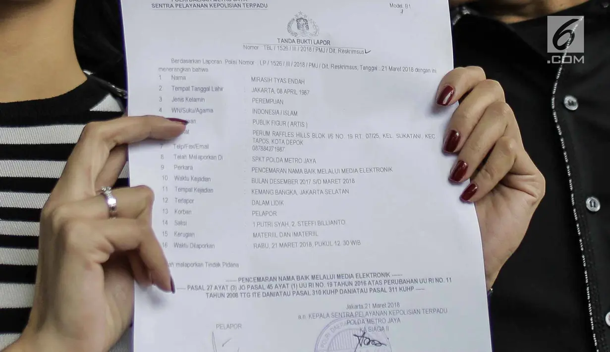 Artis peran Tyas Mirasih menunjukkan surat laporan pencemaran nama baik usai melapor ke Polda Metro Jaya, Jakarta, Rabu (21/3). Tyas melaporkan pihak yang menuduhnya telah menculik anak. (Liputan6.com/Faizal Fanani)