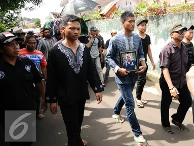 Adik kandung Achmad Kurniawan, Kurnia Meiga (tengah) mengantar jenazah sang kakak menuju pemakaman di kawasan Cijantung, Jakarta, Rabu (11/1). Kiper Arema FC, Achmad Kurniawan wafat di usia 37 tahun. (Liputan6.com/Helmi Fithriansyah)