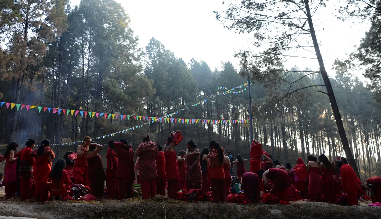 Para wanita Hindu Nepal bersiap melakukan ritual mandi suci selama Festival Swasthani Brata Katha di Hutan Changu Narayan di Bhaktapur, Nepal, (8/2). (AFP Photo / Prakash mathema)