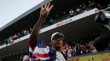 Pembalap asal Inggris dari tim Marcedes, Lewis Hamilton merayakan kemenangannya meraih juara dunia F1 untuk yang ke empat kalinya di Autodromo Hermanos Rodrigue, Meksiko (29/10). (AP Photo / Rebecca Blackwell)