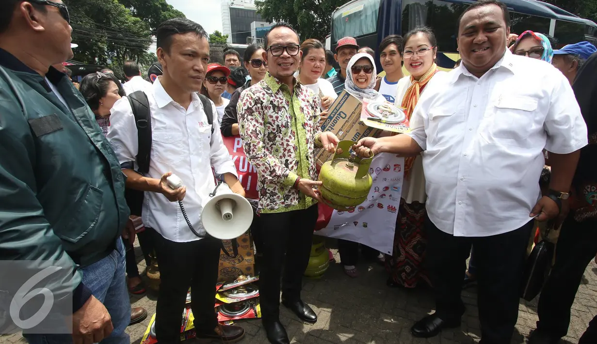 Menteri Tenaga Kerja dan Transmigrasi Hanif Dhakiri menyerahkan bantuan tabung gas secara simbolis saat melepas keberangkatan rombongan Pendukung Jokowi Peduli Garut di Tugu Proklamasi, Jakarta, Rabu (28/9). (Liputan6.com/Immanuel Antonius) 