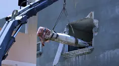 Pakar peledak Hamas mengeluarkan rudal Israel yang tidak meledak setelah menghantam di sebuah rumah di Khan Yunis, Jalur Gaza selatan (20/5/2021). Dari sekian banyak rudal Israel yang meluncur dan meledak di Gaza, ada beberapa rudal yang tak meledak usai menghantam sasaran. (AFP/Said Khatib)