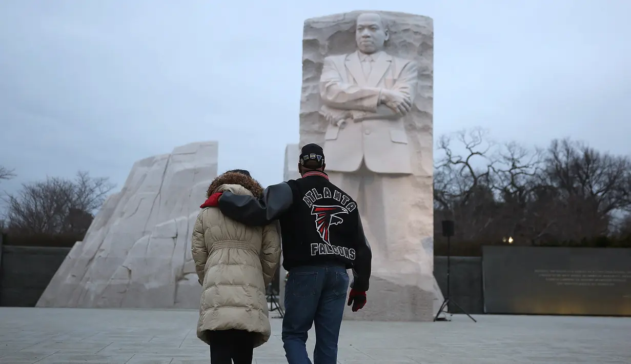 Warga AS memperingati 'Hari Martin Luther King Jr' di depan Patung Martin Luther King Jr, Washington DC, AS, Senin (16/1). Mereka berdoa sekaligus mengenang kembali perjuangan Martin Luther King Jr. (Joe Raedle / Getty Images / AFP)