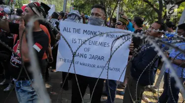 Seorang massa membawa poster dalam aksi bela Rohingya bersama Bang Japar atau Barisan Jawara dan Pengacara di depan Kedutaan Besar Myanmar, Jakarta, Jumat (8/9). Aksi ini dalam rangka solidaritas terhadap muslim Rohingya. (Liputan6.com/Faizal Fanani)