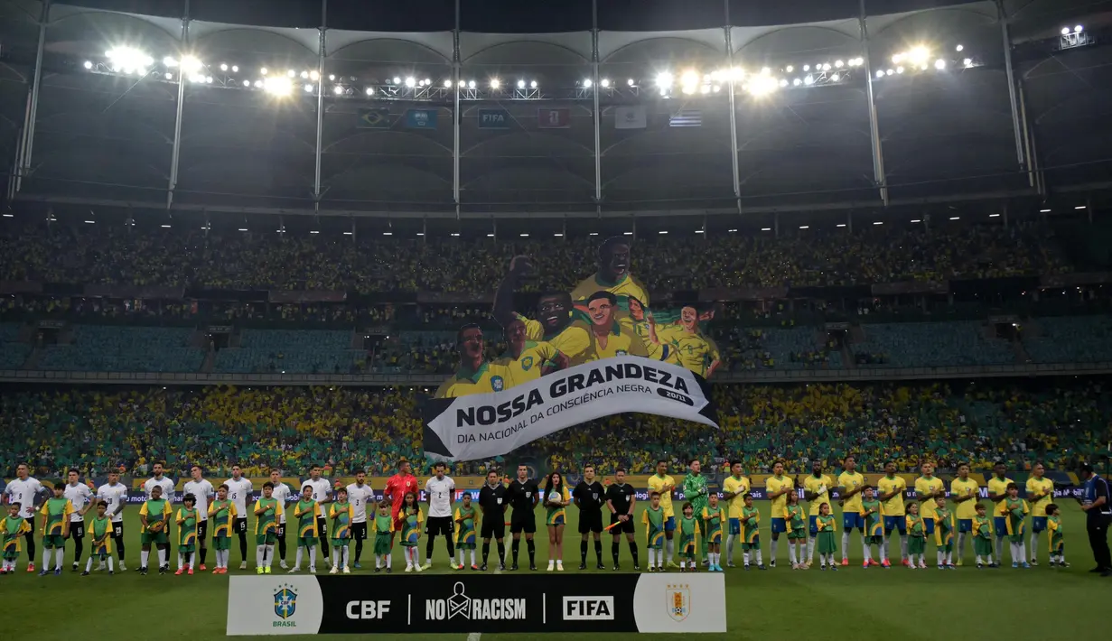 Para pemain Uruguay (kiri) dan Brasil berpose untuk berfoto sebelum dimulainya pertandingan sepak bola kKualifikasi Piala Dunia FIFA 2026 zona Amerika Selatan di stadion Arena Fonte Nova di Salvador, Brasil, pada Selasa 19 November 2024 waktu setempat atau Rabu 20 November 2024 pagi Waktu Indonesia Barat. (NELSON ALMEIDA/AFP)