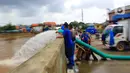 Petugas Sudin Sumber Daya Air (SDA) membuang air ke kali Ciliwung saat banjir yang merendam kawasan Kampung Melayu Kecil, Bukit Duri, Jakarta, Selasa (25/2/2020). Banjir tersebut akibat luapan sungai Ciliwung. (merdeka.com/magang/ Muhammad Fayyadh)