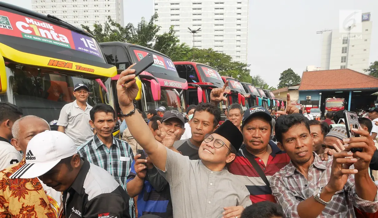 Ketua Umum PKB Muhaimin Iskandar berswafoto dengan peserta  mudik gratis PKB di Taman Ismail Marzuki, Cikini, Jakarta, Minggu (10/6). Mudik gratis PKB  tersebut bertajuk "C1NTA", singkatan dari Cak Imin untuk Indonesia. (Liputan6.com/Herman Zakharia)