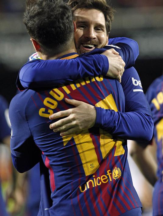 Striker Barcelona, Lionel Messi, memeluk Philippe Coutinho usai mencetak gol ke gawang Valencia pada laga leg kedua semifinal Copa del Rey di Stadion Mestalla, Kamis (8/2/2018). Barcelona menang 2-0 atas Valencia. (AP/Alberto Saiz)