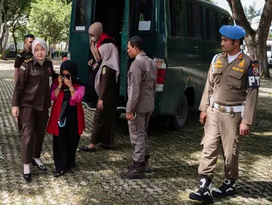 Para wanita yang dinyatakan bersalah melanggar hukum Islam, di antaranya seorang wanita yang belum menikah terbukti bersalah berciuman dengan seorang pria saat siaran langsung TikTok, tiba untuk menjalani hukuman cambuk di depan umum di Taman Bustanussalatin, Banda Aceh, Aceh, Kamis (2/7/2026). (AP Photo/Reza Saifullah)