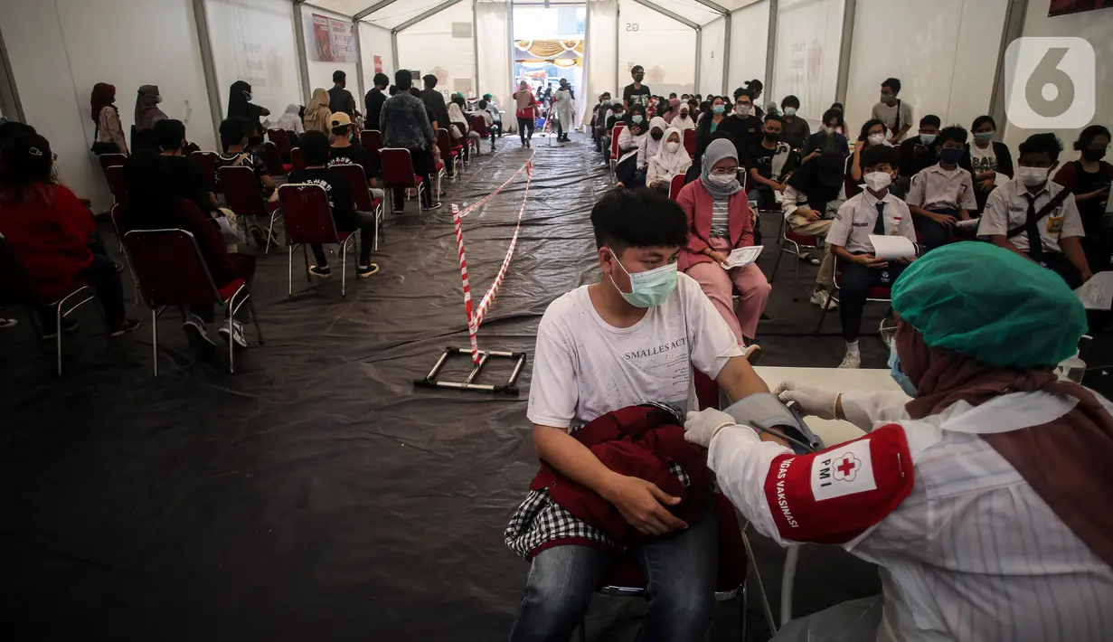 Petugas kesehatan melakukan screening terhadap penerima vaksin covid-19 di Gudang Darurat Nasional Palang Merah Indonesia, Jakarta, Kamis (15/7/2021). PMI turut menggelar vaksinasi massal untuk mempercepat pencapaian target pemerintah untuk mewujudkan kekebalan komunitas. (Liputan6.com/Johan Tallo)
