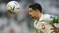Striker Polandia, Robert Lewandowski, menyundul bola saat melawan Arab Saudi pada laga Piala Dunia di Stadion Education City, Qatar, Sabtu (26/11/2022). (AP/Francisco Seco)