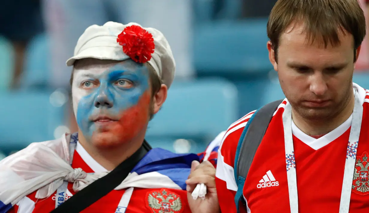 Suporter Rusia terlihat sedih setelah tim kesayangannya kalah dari Kroasia pada laga perempat final Piala Dunia 2018 di Stadion Olimpiade Fisht, Sabtu (7/7). Tuan rumah Rusia tumbang lewat adu penalti melawan Kroasia 3-4. (AP/Darko Bandic)