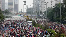 Sejumlah orang memadati Jalan Sudirman-Thamrin, Jakarta saat menikmati Car Free Day (CFD), Minggu (26/3). Libur panjang menjelang Nyepi (28/3), sebagian warga Jakarta memilih menghabiskan waktu dengan berolahraga di area CFD. (Liputan6.com/Faizal Fanani)