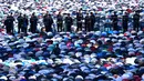Sejumlah petugas kepolisian berjaga saat umat muslim Rusia melaksanakan salat Idul Fitri di luar masjid di pusat kota Moskow, Selasa (5/7). Perayaan Idul Fitri 1437 H di Rusia jatuh pada hari ini. (Kirill KUDRYAVTSEV/AFP)