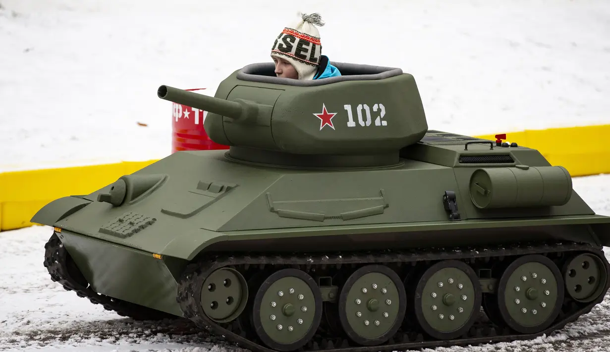 Seorang anak laki-laki mengendarai model tank T-34 era Soviet yang legendaris di objek wisata petualangan anak-anak Tankodrom di taman Sokolniki di Moskow, Rusia (6/1/2020). Model tank ini memiliki mesin pembakaran internal dan kontrol seperti aslinya. (AP Photo/Alexander Zemlianichenko)