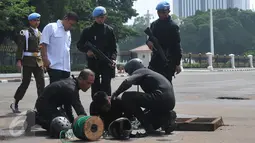 Pasukan katak TNI AL mempersiapkan peralatan untuk menyusuri gorong-gorong di depan Istana Merdeka, Jakarta, Kamis (3/3). Pasukan katak ini dilibatkan menyusul temuan kulit kabel yang sebelumnya ditemukan di gorong-gorong. (Liputan6.com/Gempur M Surya)