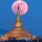 Penampakan fenomena supermoon dari balik pagoda Uppatasanti di langit Naypyitaw, Myanmar, Minggu (3/12). Supermoon adalah istilah populer untuk menyebut purnama yang posisi orbit Bulan sedang berada di jarak terdekat dengan Bumi. (AP/Aung Shine Oo)