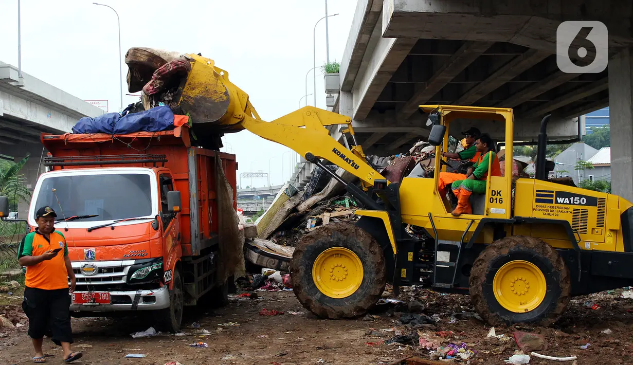 Petugas PPSU DKI Jakarta menggunakan alat berat saat mengangkut sampah sisa banjir di bawah Tol Becakayu, Cipinang Melayu, Jakarta Timur, Rabu (8/1/2020). Sampah sisa banjir tersebut selanjutnya diangkut ke TPA Bantar Gebang. (merdeka.com/Magang/Muhammad Fayyadh)