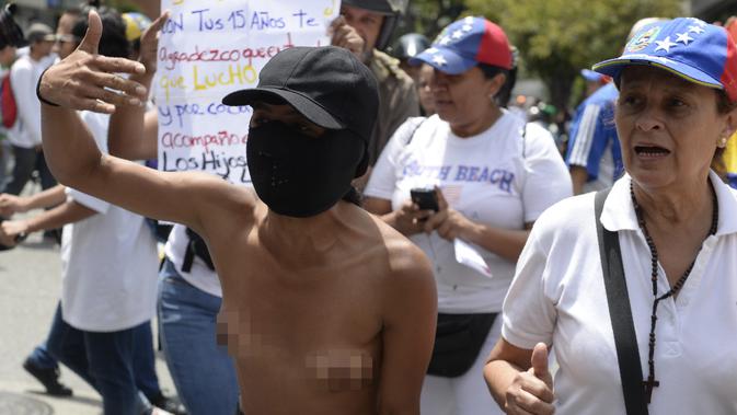 Seorang wanita bertelanjang dada sambil berunjuk rasa menentang Presiden Venezuela Nicolas Maduro di Caracas, Sabtu (6/5). Aksi massa wanita itu berlangsung di sejumlah kota besar di negara penghasil minyak di Amerika Selatan. (AFP PHOTO / FEDERICO PARRA)