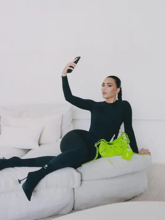 Di sini Kim Kardashian tampil mengenakan full body suit serba hitam, yang dilengkapi dengan kaus kaki, serta heels hitam. Foto: Instagram.