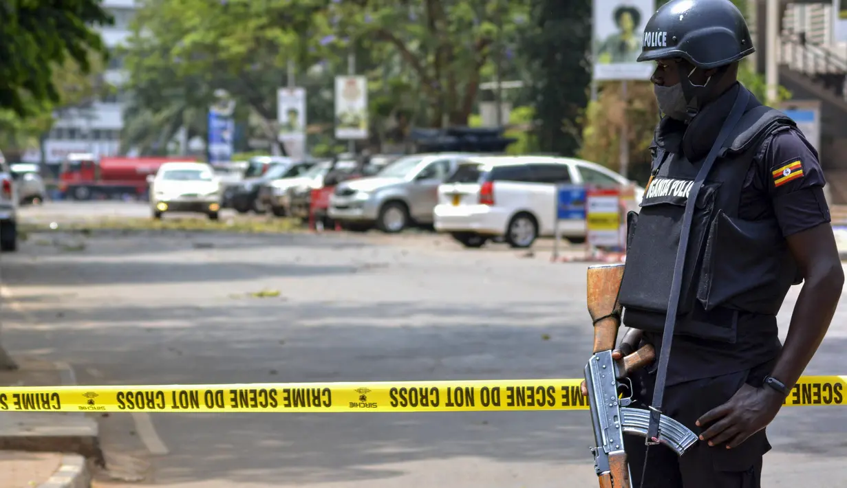 Pasukan keamanan mengamankan lokasi ledakan di sebuah jalan dekat gedung parlemen di Kampala, Uganda (16/11/2021).  Serangan yang terjadi di dekat parlemen Uganda dan markas polisi terjadi hampir bersamaan dengan selisi kurang dari tiga menit. (AP Photo/Hajarah Nalwadda)