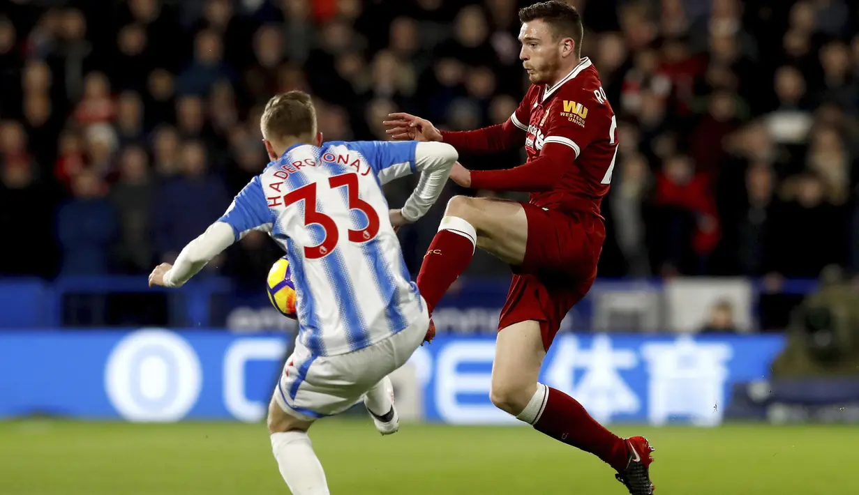 Pemain Liverpool, Andrew Robertson (kanan) berebut bola dengan pemain Huddersfield Town, Florent Hadergjonaj pada lanjutan Premier League di John Smith's Stadium, Huddersfield, (30/1/2018). Liverpool menang 3-0. (Martin Rickett/PA via AP)