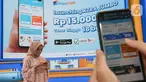 Pengunjung mencoba aplikasi Maucash di sela-sela peluncuran Mauringan XTRA Jumbo pada Event GIIAS Jakarta 2021, Jumat (19/11/2021). Perusahaan Fintech Lending yang terhubung ke ekosistem Grup Astra menargetkan penyaluran pinjaman Maucash mencapai Rp 2 triliun hingga akhir tahun. (Liputan6.com)