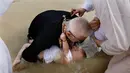 Imam Kristen Ortodoks Serbia membaptis seorang bayi di perairan Sungai Yordan di dekat kota Jericho (4/3). Di tempat ini diyakini Yesus Kristus dibaptis oleh Yohanes Pembaptis. (AFP Photo/Gali Tibbon)