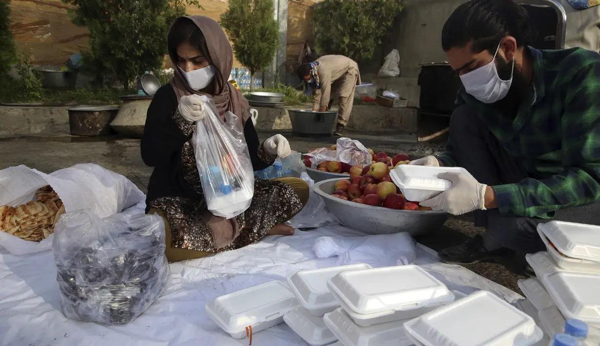 Sukarelawan menyiapkan makanan berbuka puasa gratis untuk orang-orang yang membutuhkan selama bulan puasa suci Ramadan di Kabul, Afghanistan, Kamis (7/5/2020). Muslim di seluruh dunia melewati Ramadan tahun ini di tengah pandemi virus corona COVID-19 dan PHK. (AP Photo/Rahmat Gul)