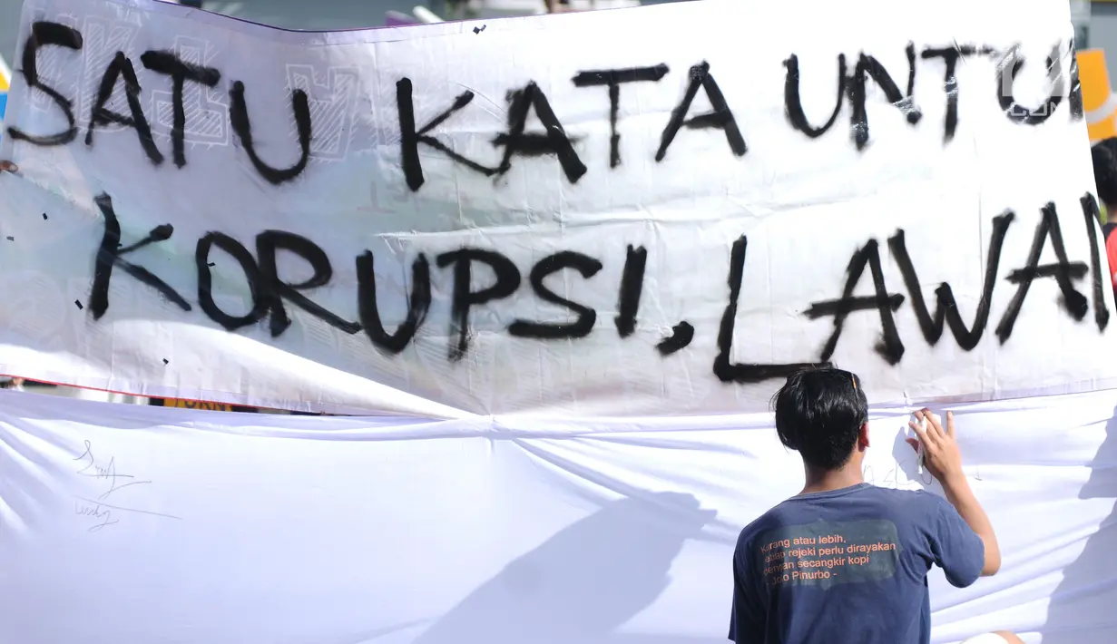 Warga menandatangani spanduk dukungan anti korupsi yang dibentangkan saat Hari Bebas Kendaraan di kawasan Bundaran HI, Jakarta, Minggu (10/12). Aksi dilakukan untuk memperingati Hari Anti-Korupsi Sedunia, 9 Desember. (Liputan6.com/Helmi Fithriansyah)