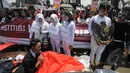 Seorang demonstran yang berada di dalam peti melakukan aksi teatrikal di depan Istana Merdeka, Jakarta, Senin (16/2/2015). Aksi teatrikal untuk mendesak Presiden Jokowi untuk melantik Budi Gunawan sebagai kapolri. (Liputan6.com/Herman Zakharia). 