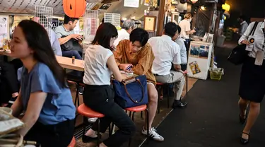 Orang-orang berkumpul di "izakaya", sebuah bar tradisional Jepang, pada malam hari di Tokyo, 4 September 2020. Interior tempat ini biasanya dari kayu, yang semakin menambah kesan tradisional. (Photo by Charly TRIBALLEAU / AFP)