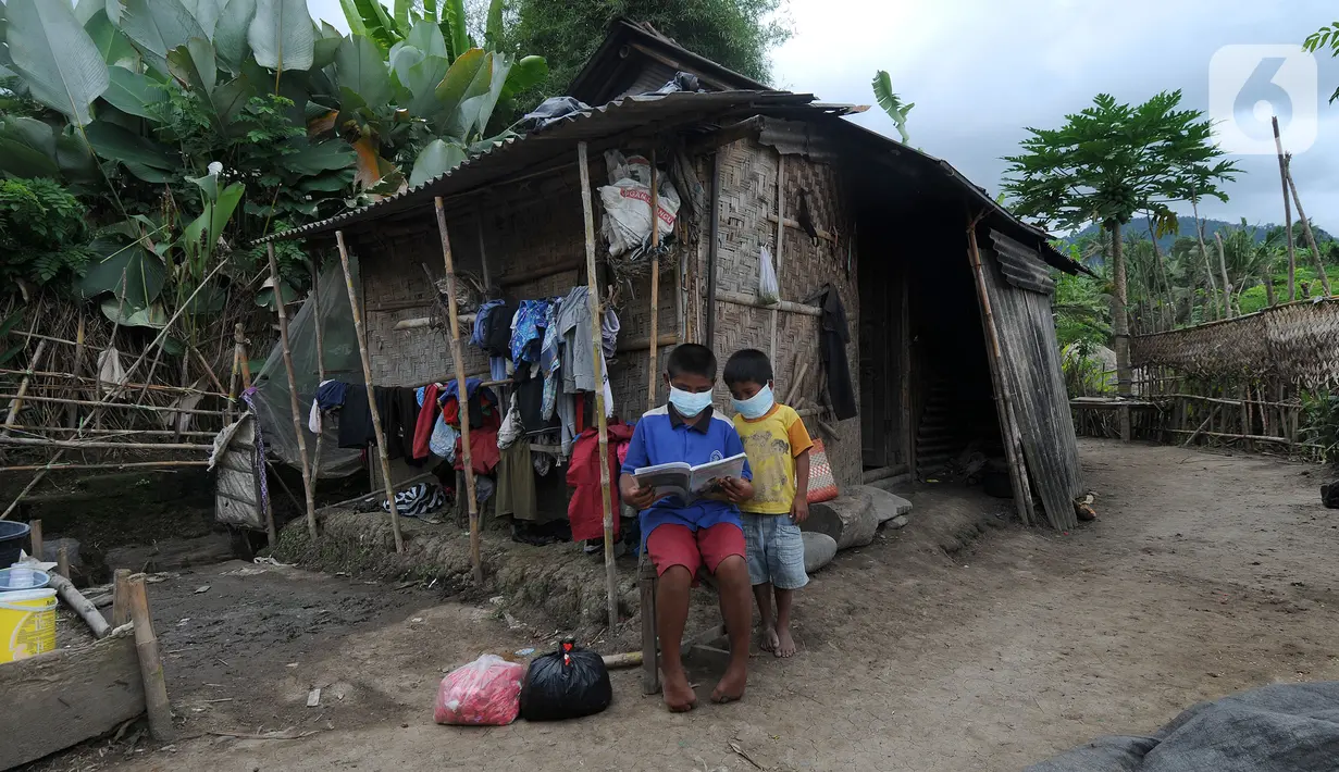 Dua anak membaca buku di depan sebuah rumah di kawasan Sidemen, Karangasem, Bali, Kamis (2/9/2021). Badan Pusat Statistik Provinsi Bali mengumumkan penduduk miskin Bali kini berjumlah 201.970 orang dari sekitar 4,32 juta orang penduduk Bali. (merdeka.com/Arie Basuki)