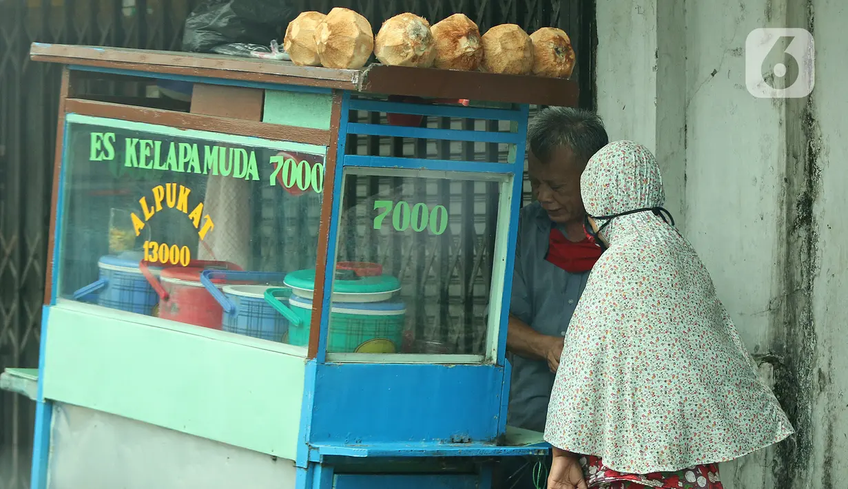 Pedagang sedang melayani pembeli di kawasan Jatinegara, Jakarta, Jumat (5/2/2021). Di tengah lonjakan kasus COVID-19 masih banyak masyarakat yang abai terhadap protokol kesehatan. (Liputan6.com/Herman Zakharia)