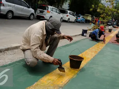 Pekerja menyelesaikan pembangunan Trotoar Ramah Disabilitas di Jalan Hidup Baru, Kalimati, Jakarta Utara, Selasa (27/12). Nantinya trotoar ini akan dibangun sepanjang 753 meter dan lebar 2,4 meter. (Liputan6.com/Gempur M. Surya)