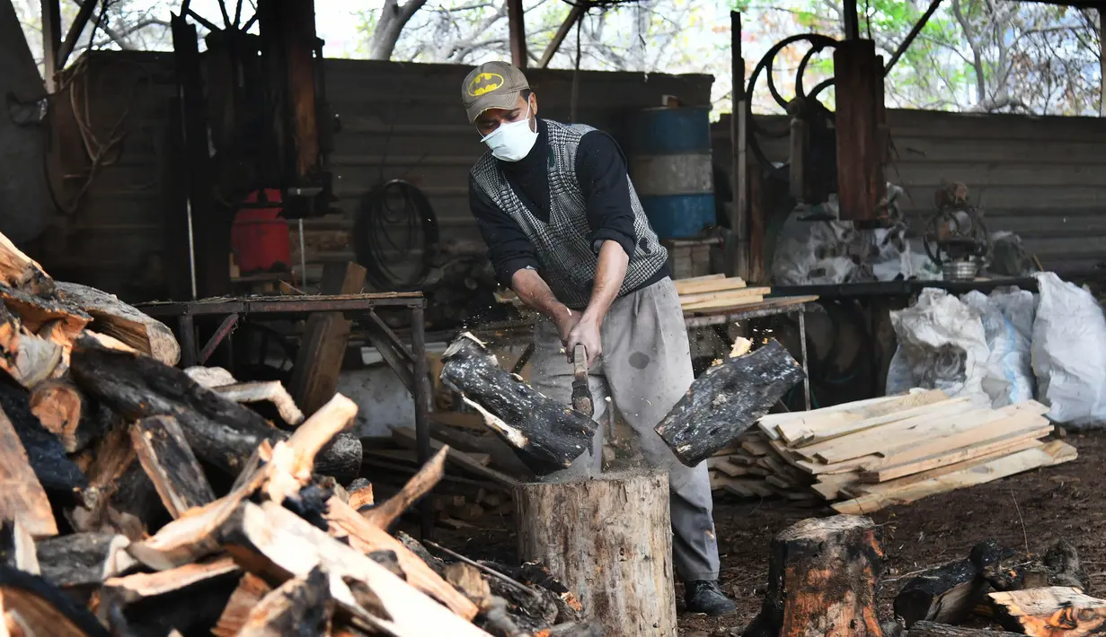 Seorang pekerja memotong kayu bakar di sebuah bengkel kerja di Damaskus, ibu kota Suriah, pada 23 November 2020. Warga Suriah mengumpulkan kayu bakar untuk menghadapi cuaca dingin. (Xinhua/Ammar Safarjalani)