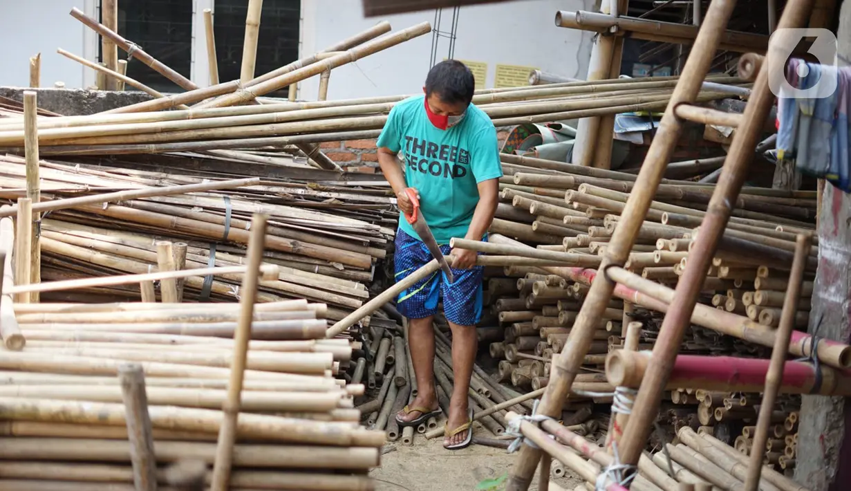 Perajin memotong bambu yang biasa digunakan sebagai tiang bendera di kawasan Manggarai, Jakarta, Kamis (6/8/2020). Bambu-bambu itu dijual dengan harga bervariasi, mulai dari Rp15ribu hingga Rp35ribu, tergantung ukurannya. (Liputan6.com/Immanuel Antonius)