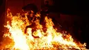 Seorang pria menunggangi kuda melewati api unggun saat festival Luminarias di San Bartolome de Pinares, Spanyol, Jumat (16/1/2020). Festival tersebut digelar setiap tahunnya, sehari sebelum perayaan Santo Antonius yang merupakan pelindung binatang. (AP Photo/Manu Fernandez)