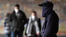 Komuter berjalan melewati Stasiun Flinders Street pada hari pertama wajib masker di tempat umum, di Melbourne, Kamis (23/7/2020). Penduduk kota terpadat kedua di Australia, Melbourne, diwajibkan mengenakan masker ketika meninggalkan rumah untuk mencegah penyebaran COVID-19. (William WEST/AFP)
